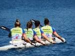Cuatro piragüistas remando en un kayak cuádruple en el agua