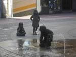 Primer plano de las esculturas de niños en la fuente con agua salpicando