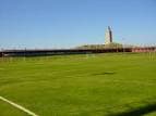 Campo de fútbol con la Torre de Hércules al fondo