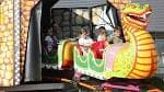 Niños disfrutando de una atracción de feria con forma de dragón en Pontevedra