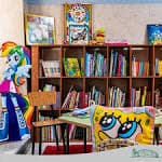 Sala de actividades o aula con estanterías de libros y decoración infantil