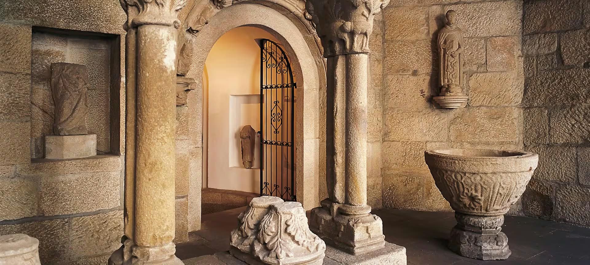 Interior de sala con columnas de piedra y elementos arqueológicos