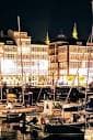 Vista nocturna del Puerto de Curuxeiras con edificios iluminados y barcos amarrados