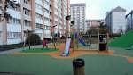 Parque infantil moderno con edificios residenciales al fondo en Elviña