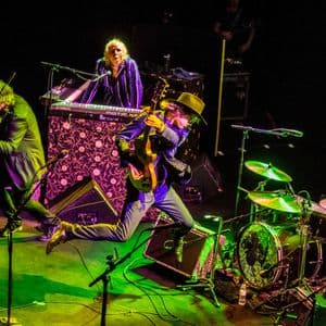 Banda de música actuando en un escenario iluminado durante un concierto
