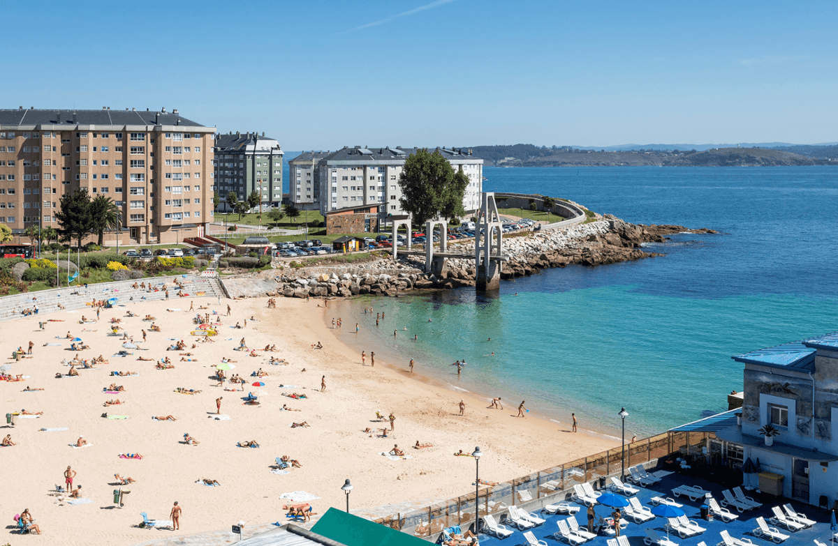 Vista aérea de la Playa de San Amaro con bañistas y edificios costeros