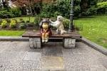 Estatua del 'Niño con perro' en un banco de piedra, un punto de interés popular del parque