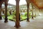 Claustro del Colexio de Fonseca con arcos y vista al jardín interior