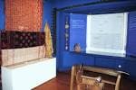 Sala temática del museo con paredes azules y exposición de textiles
