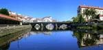 Amplia vista del Puente Viejo de Betanzos reflejado en las aguas tranquilas del río