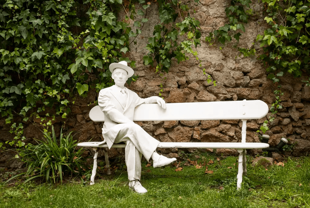 Estatua en un banco blanco en el jardín de la Casa Museo