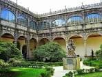 Jardín interior del Colexio de Fonseca con estatua y galerías porticadas