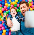 Padre e hijo disfrutando en la piscina de bolas