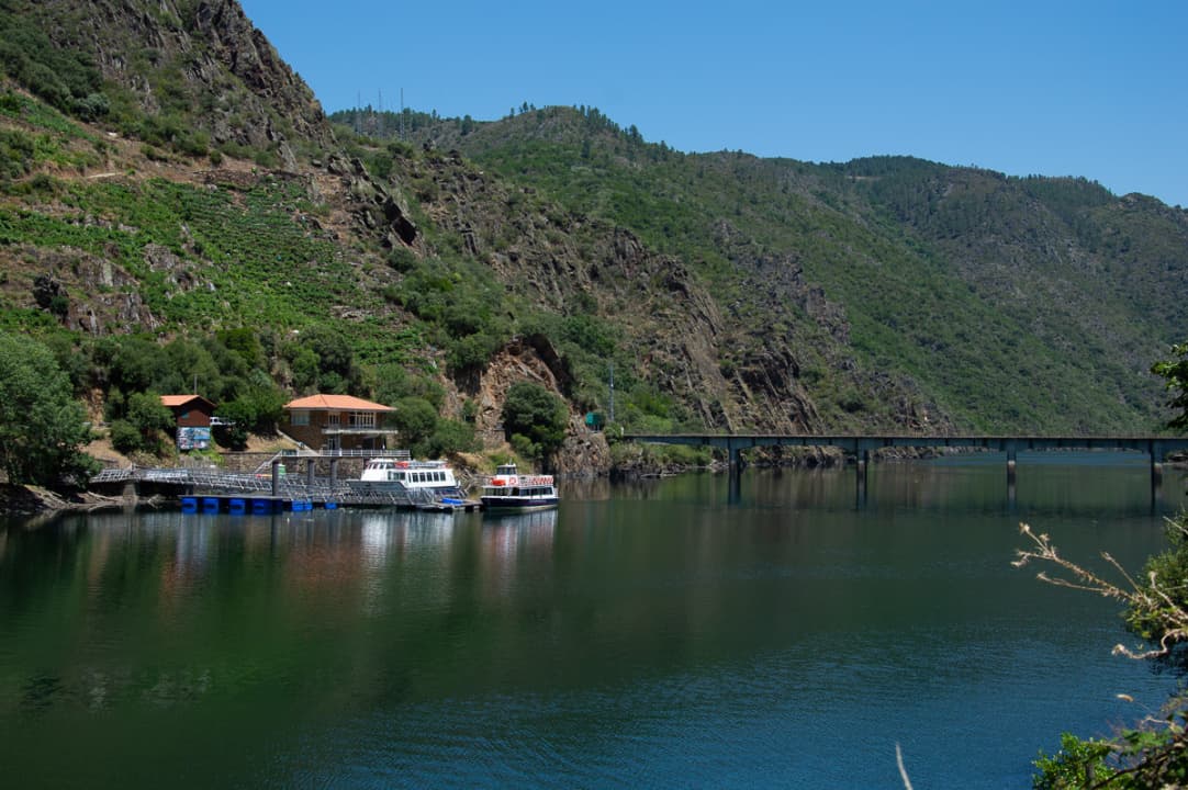 Vista panorámica del embarcadero de Ponte do Sil con catamaranes y el paisaje del cañón.
