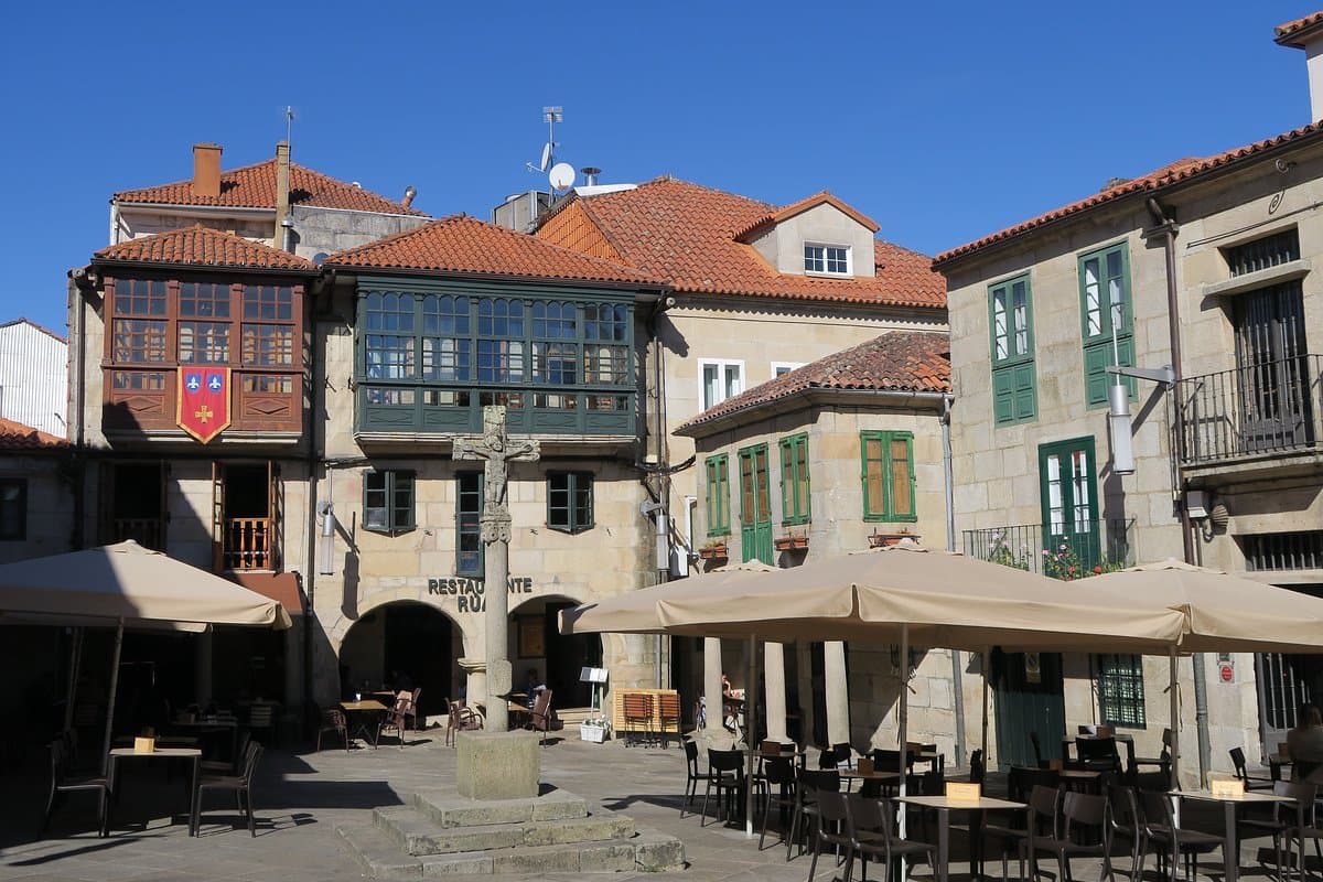 Praza da Leña con terrazas de bares y sombrillas en un día soleado.
