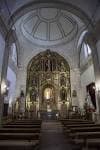 Interior de la iglesia con altar mayor y bancos de madera