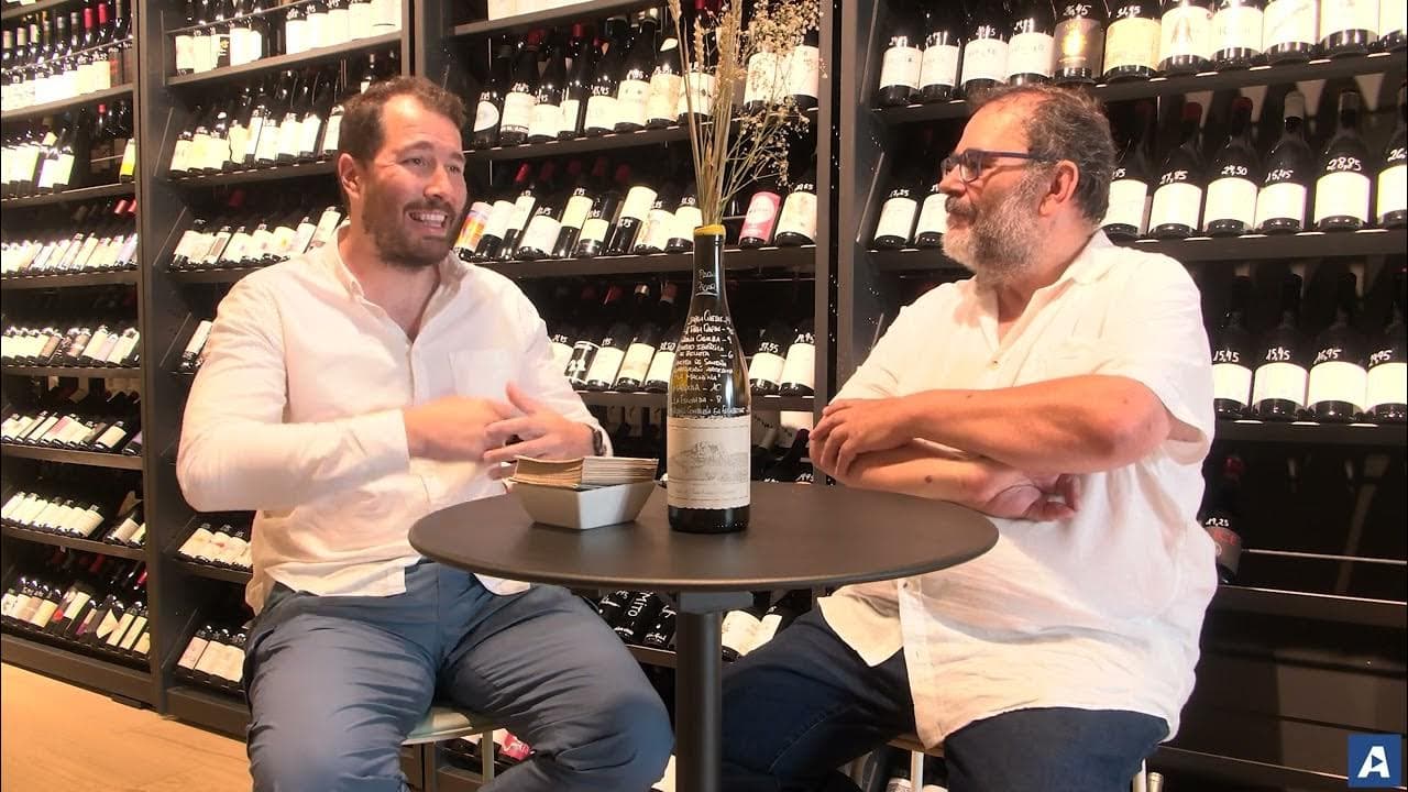 Interior de una vinoteca en Vigo con estanterías de vinos y personas