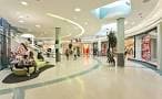Pasillo interior del centro comercial con tiendas y zona de descanso