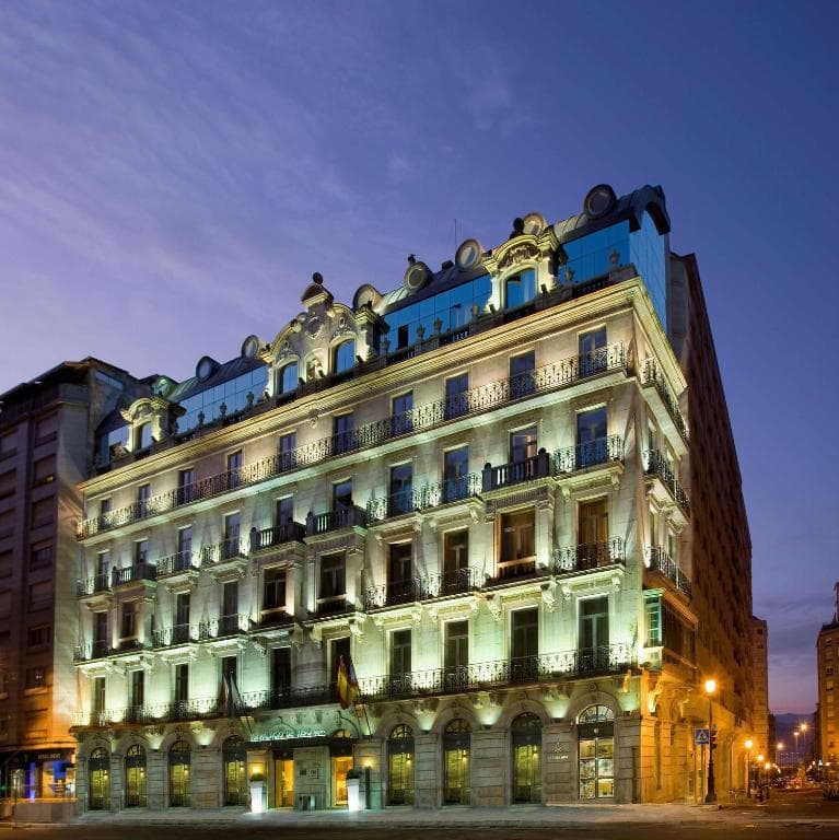 Fachada exterior del Hotel NH Collection Vigo iluminada al anochecer