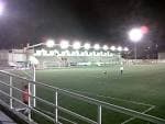 Vista nocturna del campo de fútbol municipal con iluminación