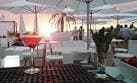 Terraza de chiringuito con sombrillas y cócteles al atardecer