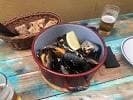 Mejillones al vapor con limón y cerveza en mesa de madera