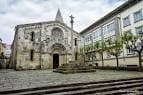 Vista frontal de la Colegiata de Santa María del Campo y la plaza empedrada en un día nublado.