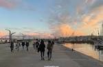 Paseo marítimo de la Dársena al atardecer con gente caminando