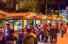 Puestos de madera iluminados en el Mercado de Nadal de Santiago de Compostela por la noche