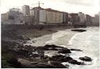 Vista de la costa rocosa y el Paseo Marítimo de A Coruña con edificios urbanos
