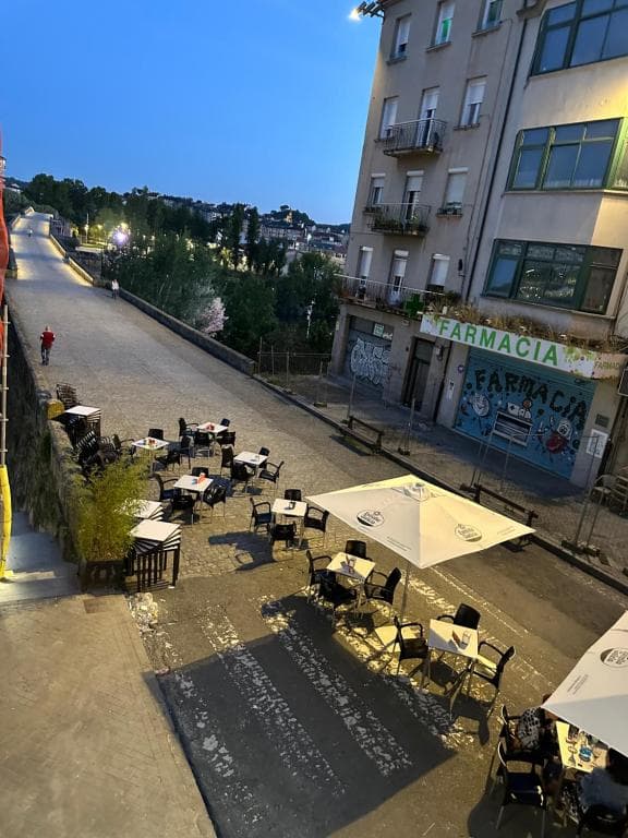 Terraza exterior con mesas y sillas en una calle de Ourense