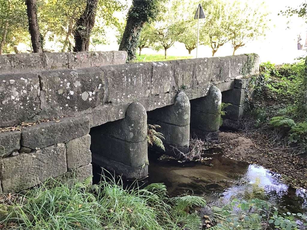 Vista del histórico Puente da Condesa de piedra sobre un arroyo
