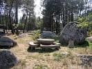 Área de picnic con mesas de piedra en el entorno boscoso de Penas de Rodas