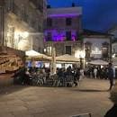 Plaza iluminada de noche con terrazas y gente, mostrando el ambiente nocturno de un lugar céntrico en Vigo