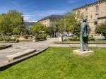 Vista panorámica de la Plaza Obispo Cesáreo con zonas verdes, césped y estatua