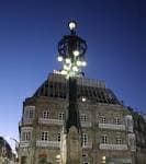 La Farola de Urzáiz iluminada al anochecer con el edificio de fondo