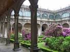 Corredor del claustro con vista al jardín florido del Colexio de Fonseca