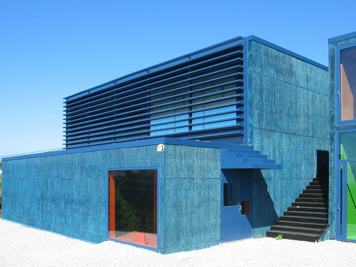 Fachada principal de un moderno centro cultural con revestimiento azul