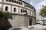Entrada principal de la Plaza de Toros de Pontevedra con una estatua en primer plano