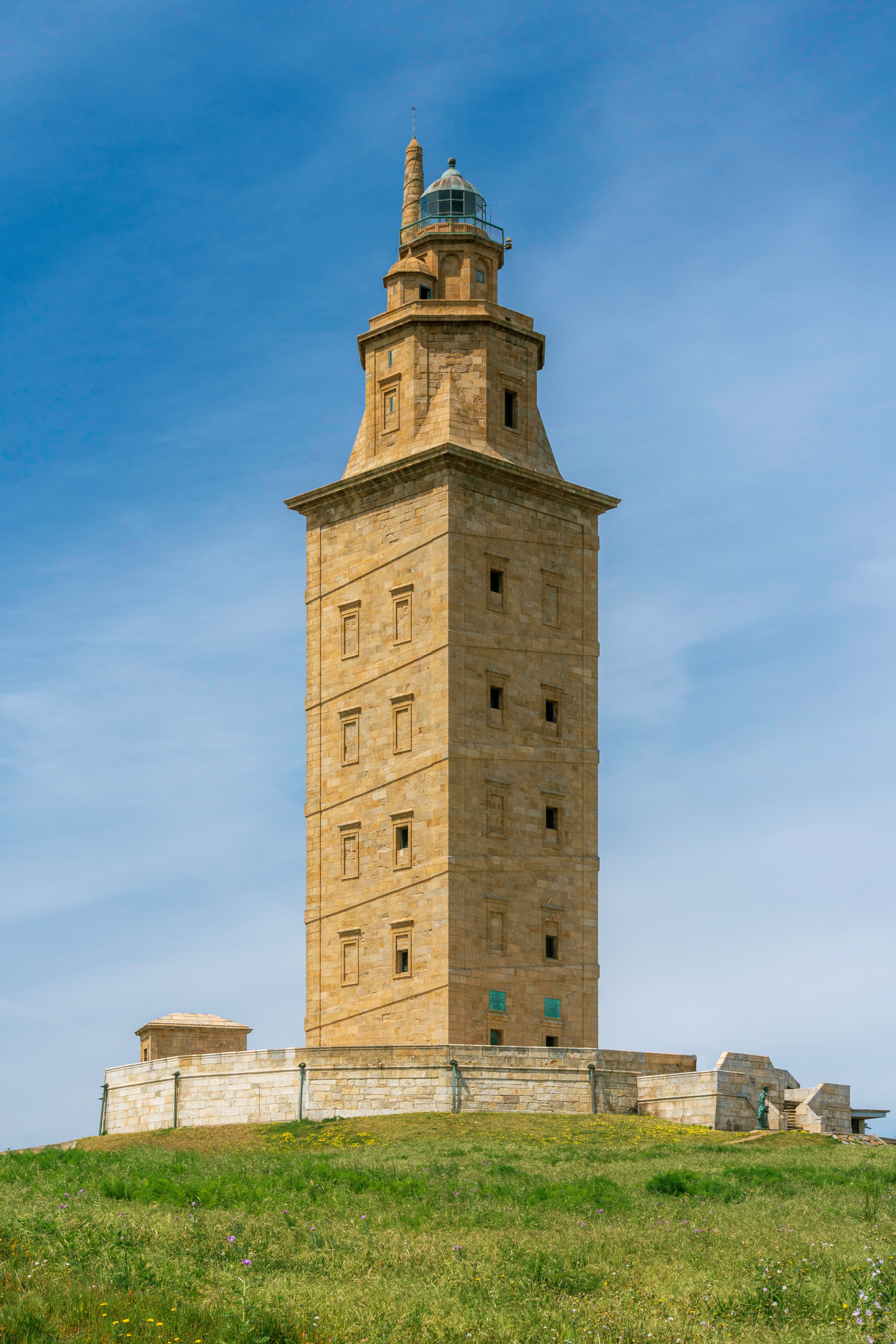 Vista frontal de la Torre de Hércules bajo un cielo azul claro