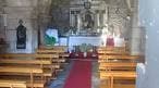 Interior de la Capilla de San Roque con altar, bancos de madera y alfombra roja.
