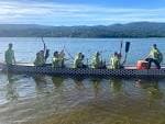 Equipo de remo en un bote dragón en el lago
