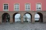 Arcos de la fachada del edificio de la Maestranza con vistas parciales al mar