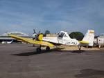 Avión blanco y amarillo estacionado en la plataforma del aeródromo