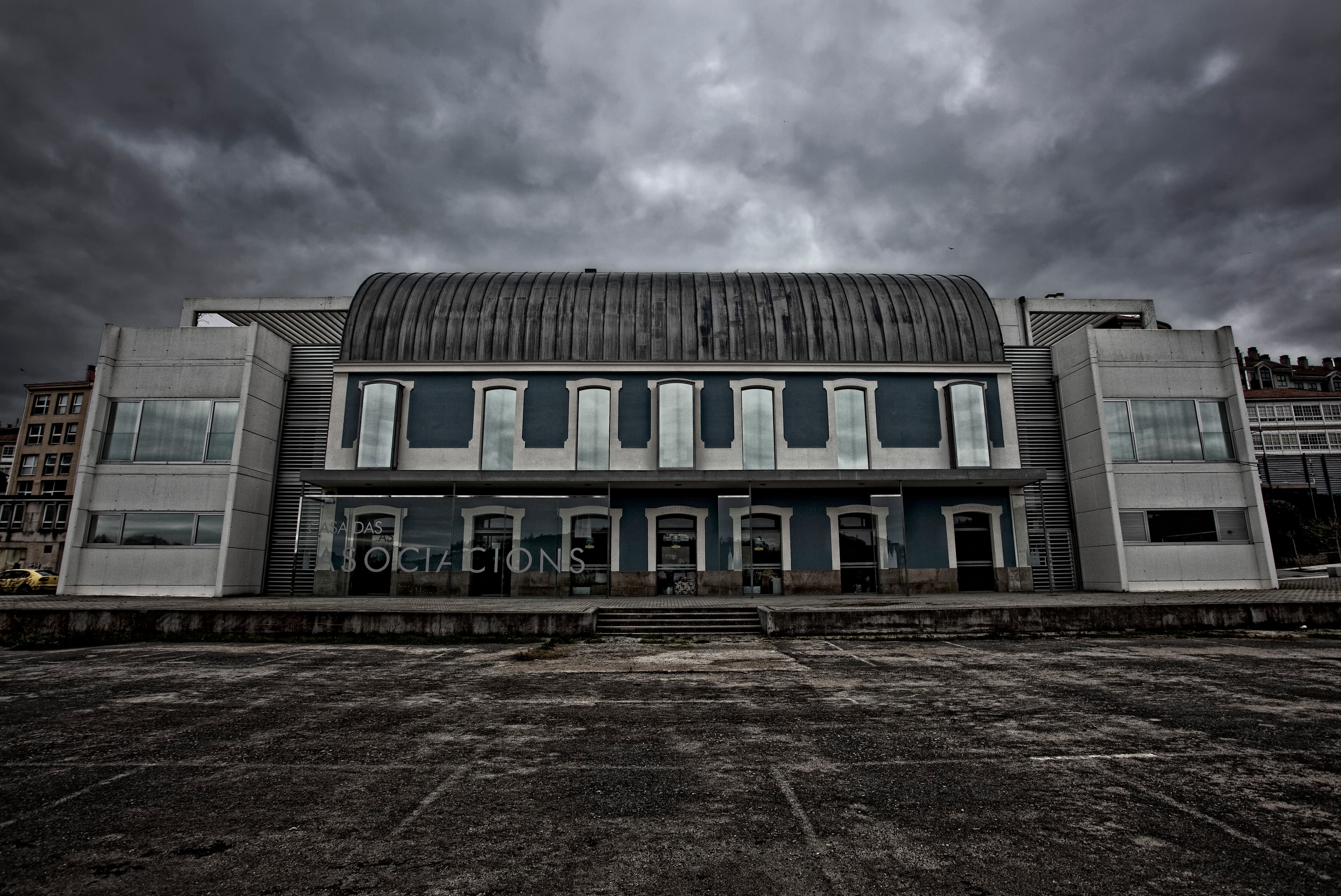 Vista frontal de la Casa das Asociacións bajo un cielo nublado