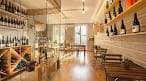 Interior de Envinissi con estanterías de vinos y mesas de madera