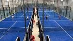 Pistas de pádel interiores con jugadores en acción desde una perspectiva elevada