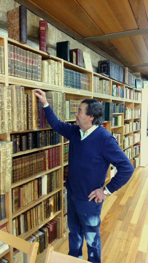 Interior de la Librería Couceiro con estanterías llenas de libros y un hombre