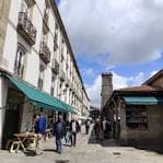 Calle con edificios históricos y toldos verdes en el casco antiguo de Santiago