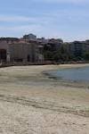 Playa de Bouzas con edificios residenciales y vegetación en la orilla